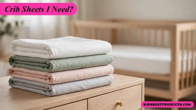 How many crib sheets do I need, shown as a stack of folded fitted sheets beside a crib